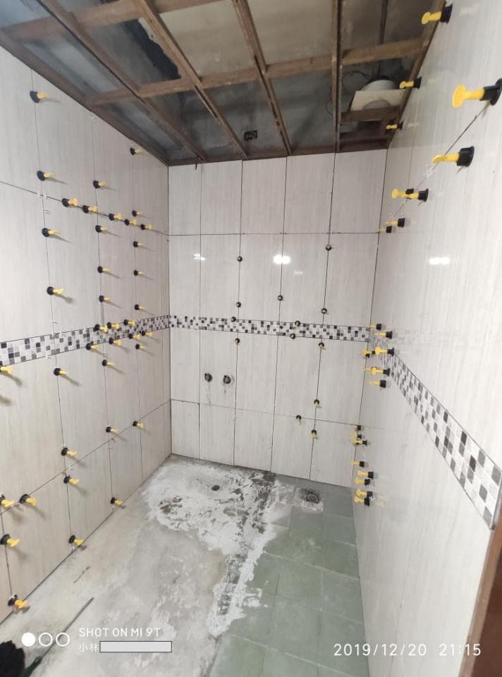 1) 這是一張浴室的照片,浴室的牆壁和地板都鋪上了瓷磚,牆上還有許多黃色的固定裝置