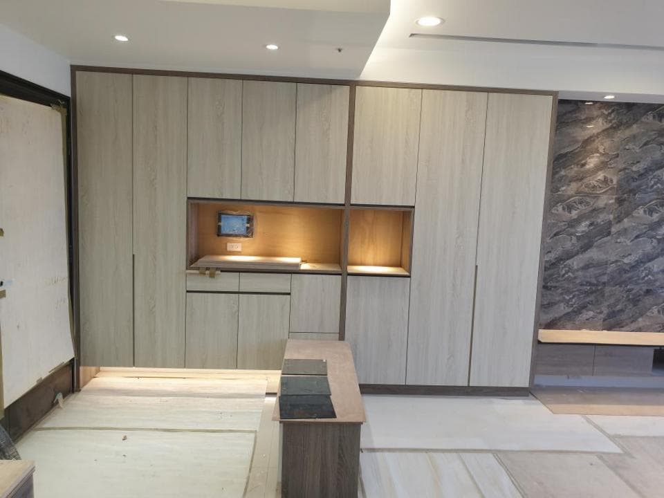 這張照片是現代化的臥室衣櫃,衣櫃採用淺色木紋設計,並設有嵌入式電視櫃,簡潔大方。