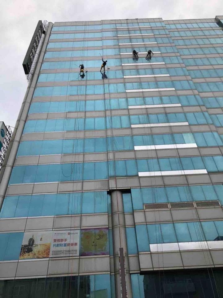 1) 這是一張高樓大廈的照片,照片中可以看到大廈的玻璃帷幕牆,有幾位工人正在清洗外牆