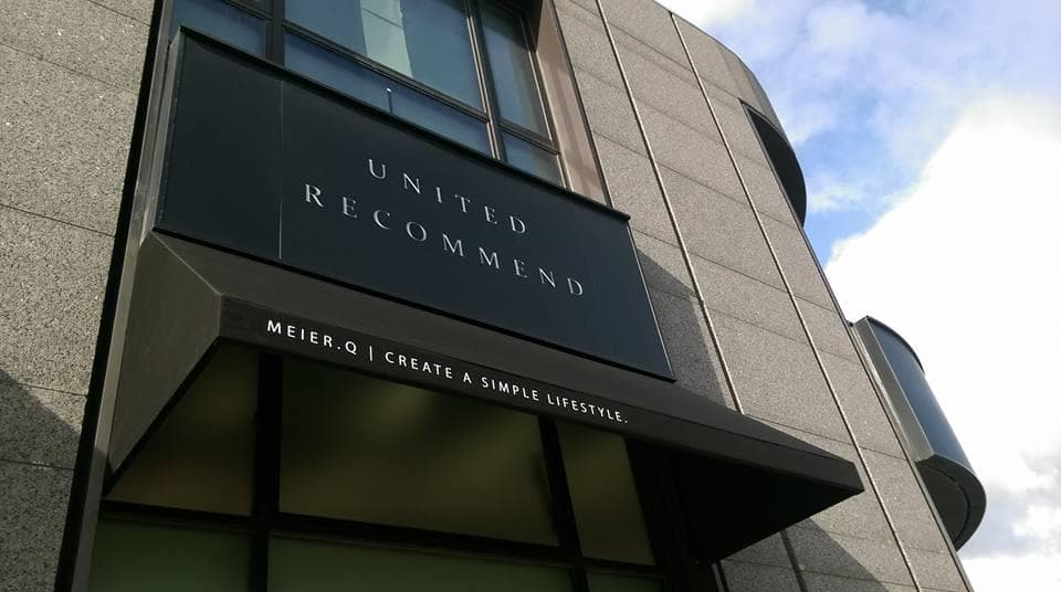 這張「UNITED RECOMMEND」招牌的照片是一家商店的外觀,招牌上寫著“MEIER.O I CREATE A SIMPLE LIFESTYLE”。