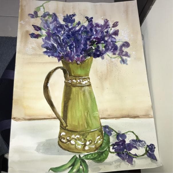 這張照片是一個綠色的花瓶,裡面插滿了紫色的小花,花瓶上還有一些精緻的圖案。