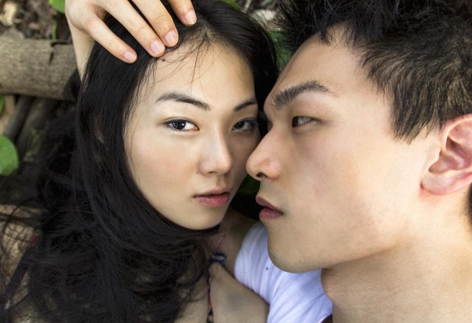 這張照片是 一對年輕男女親密地互相凝視著,男方用手輕輕地撫摸女方的臉,充滿了愛意和溫情。