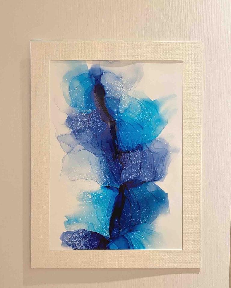 這張照片是一幅藍色抽象畫,畫中是一團團流動的藍色和白色顏料,就像是一朵朵飄浮在空中的雲朵,帶有閃爍的亮點,充滿了夢幻和神秘感。