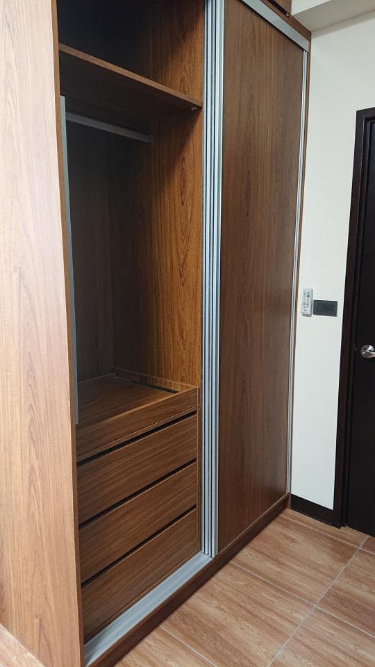 這張照片是一間房子的衣櫃,衣櫃有三個抽屜,抽屜是木頭材質的,抽屜的顏色和衣櫃的顏色相同。