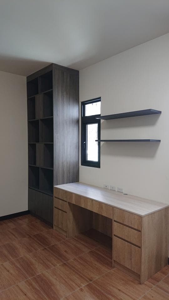 這張照片是一個現代化的書房,最重要的是一張木製的書桌,上面有抽屜,下方還有更多收納空間,看起來非常實用。