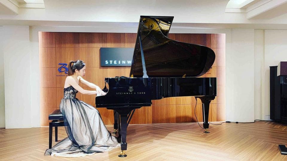 這張「鋼琴演奏」的照片是一名女子在黑色鋼琴前彈奏。