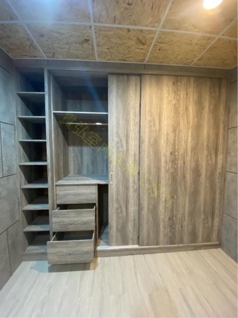 1) 照片顯示一個木質的衣櫃,櫃門是滑軌式設計,櫃門上有木紋,櫃體本身也具有層架,還有抽屜的設計