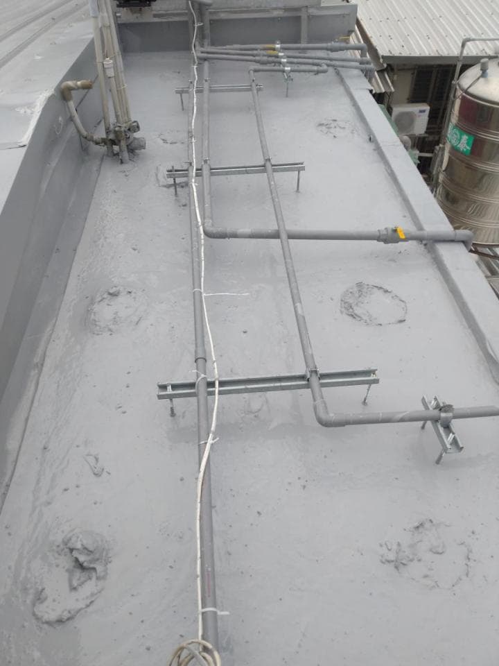 1) 照片顯示一個水泥屋頂,屋頂上有許多管道和支架