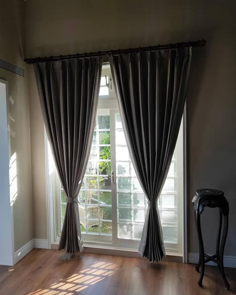 1) 照片中是一間房間內部的窗戶,窗戶上掛著兩幅灰色的窗簾,窗簾是使用窗簾杆安裝的