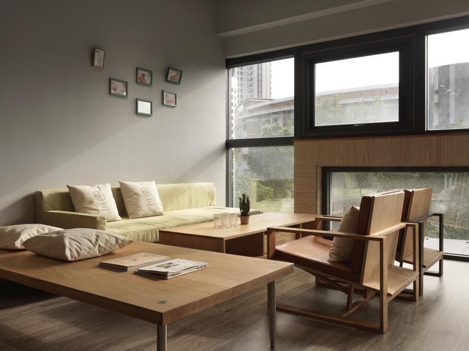 這張「客廳」的照片是,一個木質的沙發和兩個單人椅圍繞著一個咖啡桌,牆壁上裝飾著許多相框。