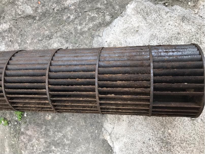 1) 一張生鏽的圓形金屬通風扇,水平放置在混凝土表面上