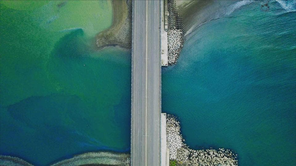 這張「橋樑」的照片是從空中拍攝的,橋樑兩側是深藍色和淺綠色的海水。