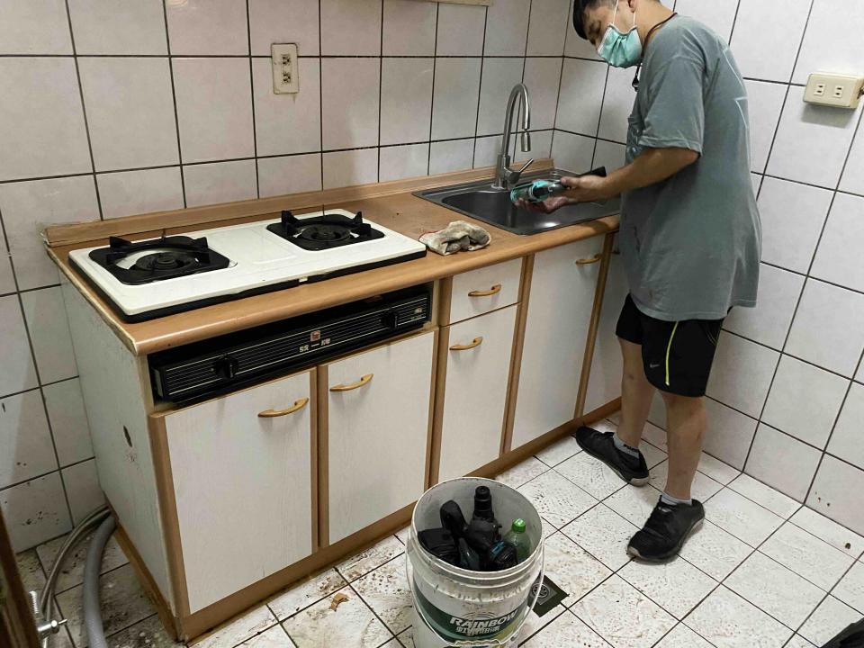 1) 照片顯示一個廚房,裡面有一個水槽、瓦斯爐和木頭櫃子