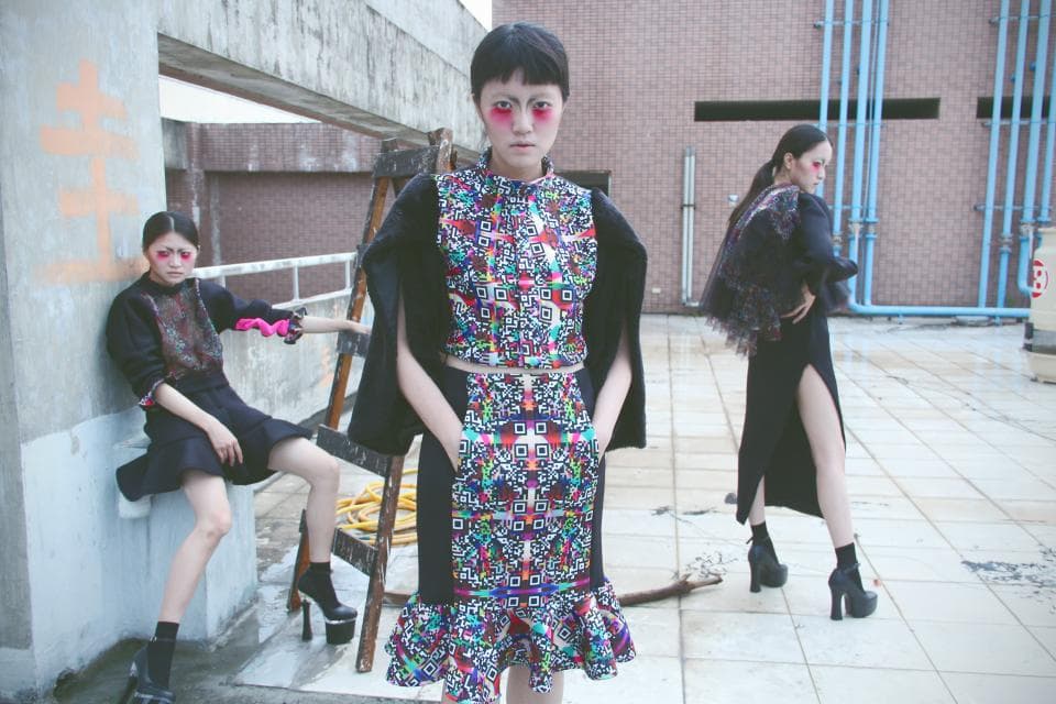 這張照片是三個女孩站在戶外,中間穿著彩色圖案洋裝的女孩是最重要的部分。她的洋裝有著複雜的幾何圖案,看起來很時尚。