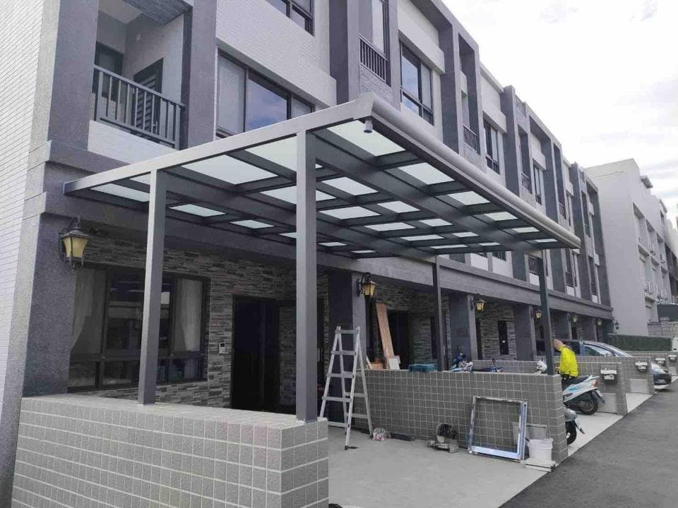 這張「玻璃屋頂遮雨棚」的照片是現代化的建築,帶有玻璃屋頂的遮雨棚,還有灰色牆壁,很漂亮。