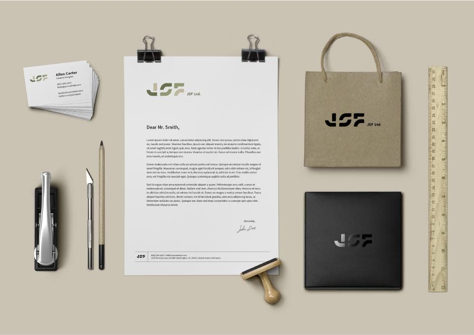 這張照片是一張公司品牌設計的展示圖,其中最重要的是公司標誌 JSF,它被應用在名片、信紙、購物袋和一個黑色的小盒子上,呈現出統一且簡潔的品牌形象。