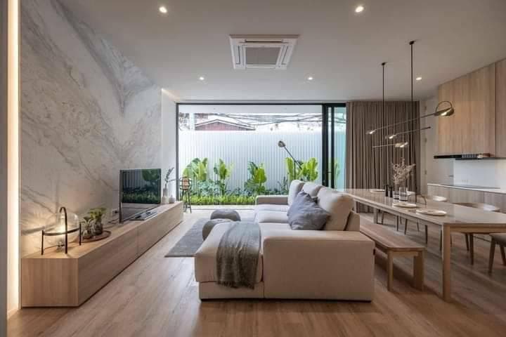 這張「客廳」的照片是現代風格的,有沙發、電視和餐桌。牆壁上裝飾著大理石紋理,看起來很時尚。客廳裡還有很多綠色植物,讓空間更清新自然。