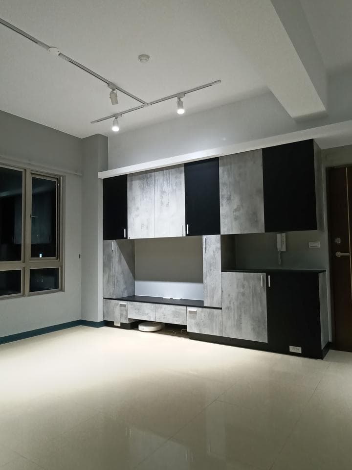 1) 照片顯示一個白色雕塑,雕塑以抽象的曲線呈現,頂端有一個金色的小球,雕塑置於一個黑色的方形底座上,背景是灰色的