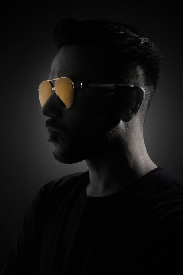這張照片是一名戴著墨鏡的男子側臉,鏡片反光,神秘感十足。
