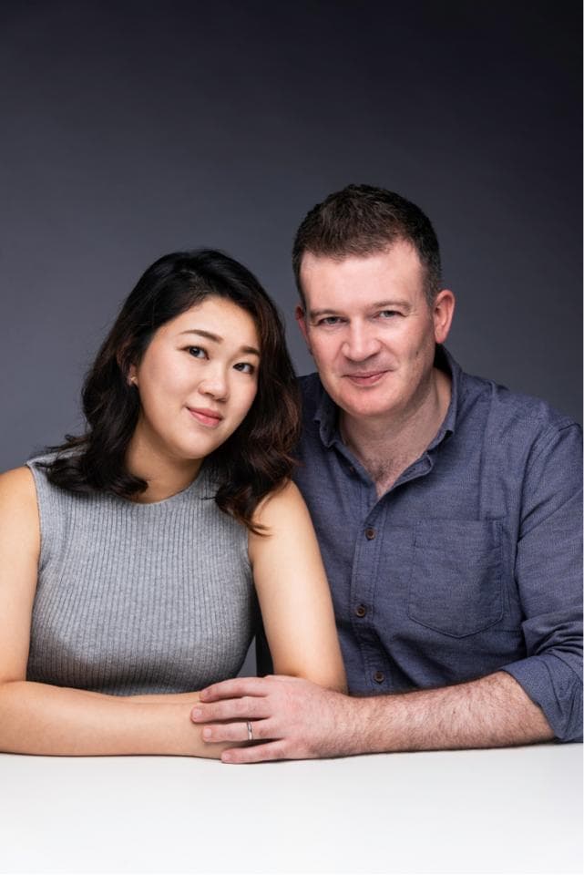 這張照片是一對夫婦,他們手牽著手,面帶微笑,看起來很恩愛。