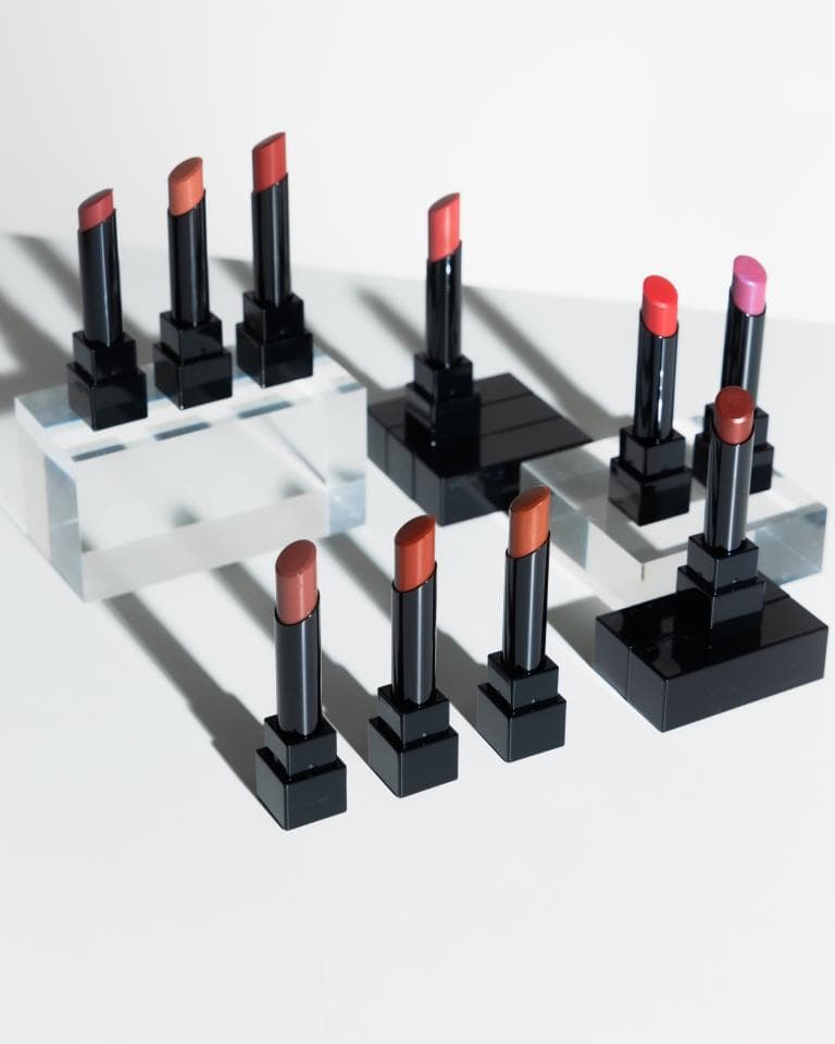 這張「唇膏」的照片是多種顏色的唇膏,擺放在不同的黑色底座上,它們整齊排列,看起來很高級。