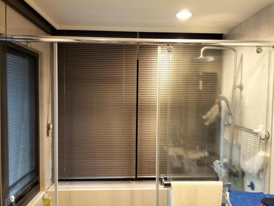 1) 照片顯示一個浴室,浴室裡有淋浴間,淋浴間的門是玻璃做的,淋浴間裡有浴簾