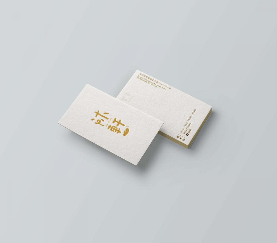 這張照片是兩張名片,其中一張名片上有金色字體的「拾穗」兩個字。