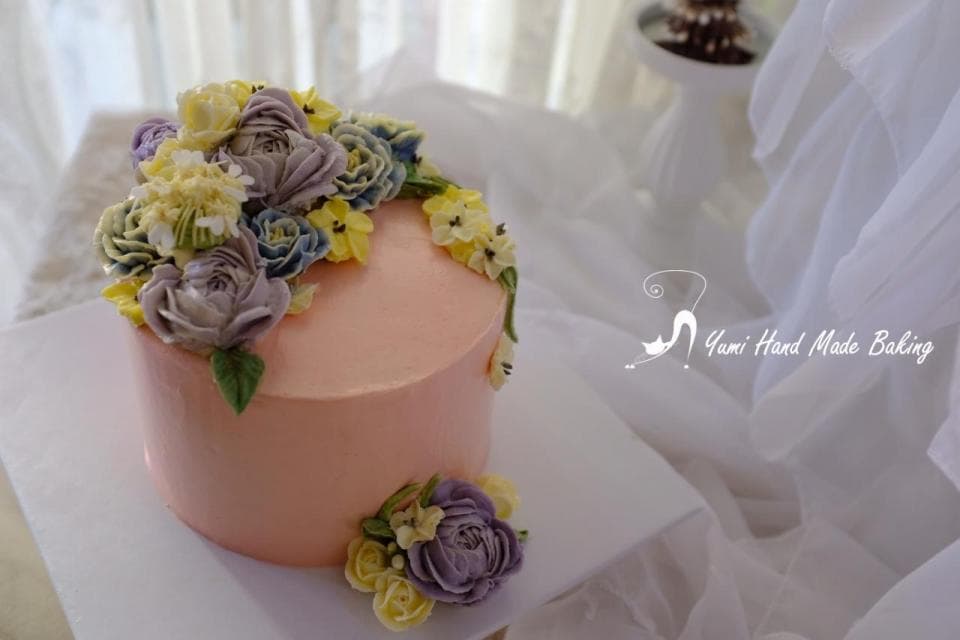 這張照片是一個粉紅色的蛋糕,上面用鮮花裝飾。鮮花以立體的形式裝飾,看起來非常逼真,給人一種清新優雅的感覺。