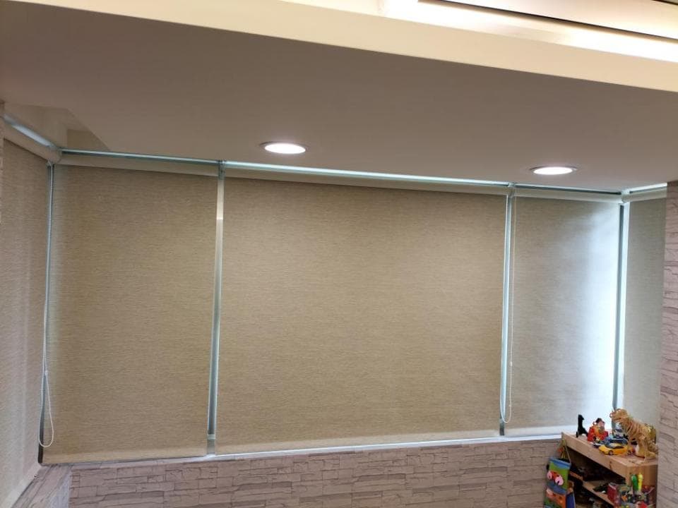 1) 照片顯示三個窗戶,窗戶上裝有米色的百葉窗,窗戶下方是石頭牆,屋頂上有天花板燈