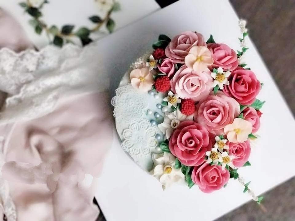 這張照片是一塊以奶油花裝飾的蛋糕,蛋糕上佈滿了各種顏色的花朵,看起來十分精緻,令人垂涎欲滴。