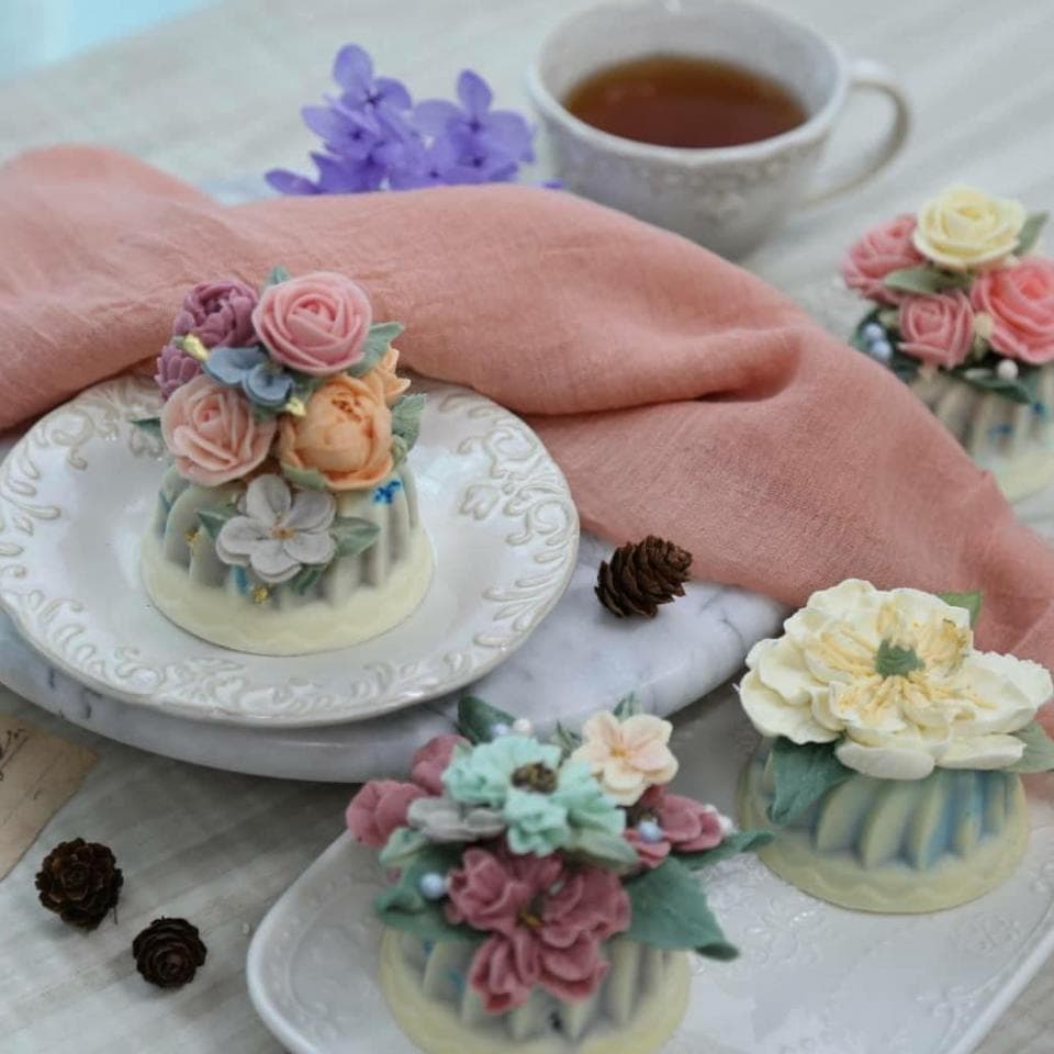 這張照片是一些裝飾著鮮花的小蛋糕。蛋糕上精緻的花朵和葉子,彷彿將春天帶入其中。