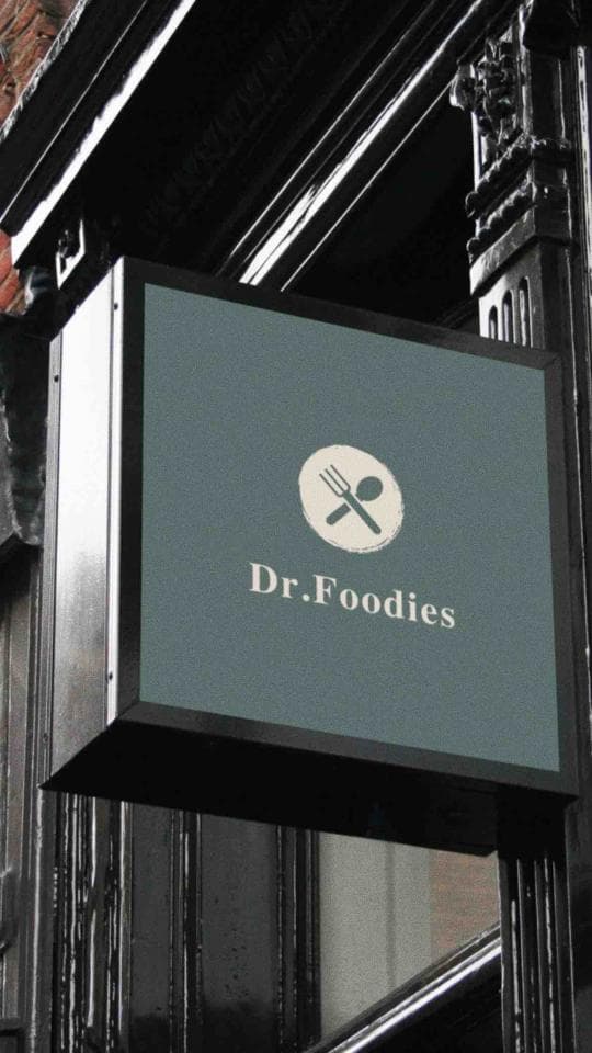 這張照片是一個招牌,上面寫著「Dr. Foodies」,旁邊有一個叉子和湯匙的圖案,代表餐廳。