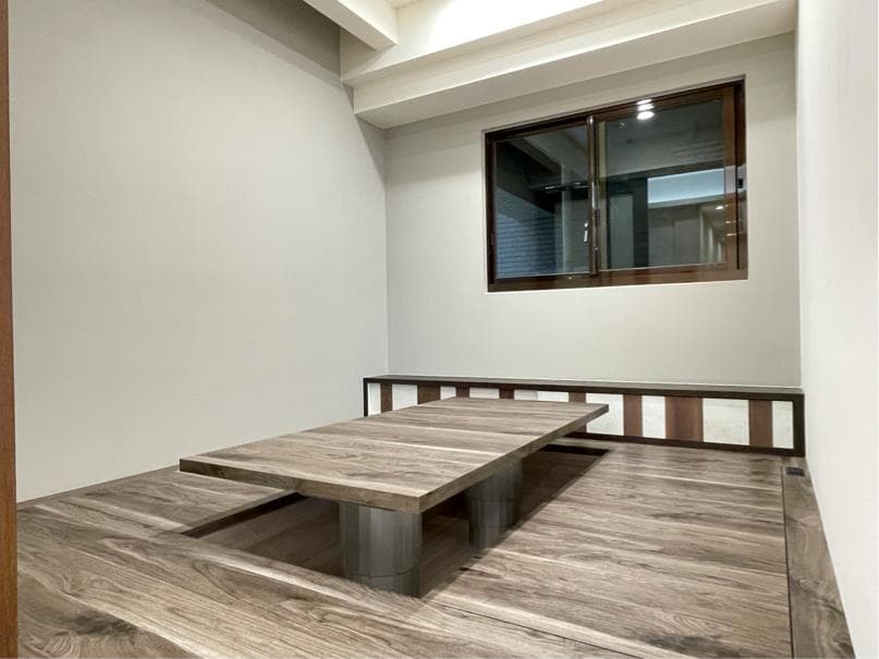 1) 一張照片顯示一個房間裡有一個木桌,木桌上有木頭的桌子,房間裡有木頭地板和一個窗戶