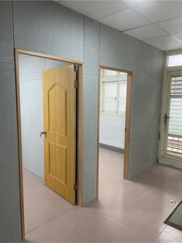 1) 照片顯示一個有兩個門的房間,房間牆壁是水泥牆,地板是淺灰色磁磚