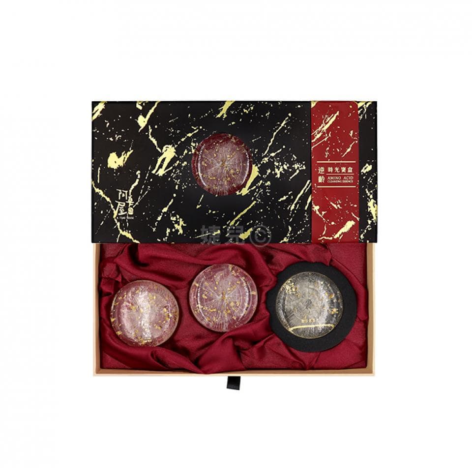 這張照片是一盒精緻的禮物盒,盒內放著三塊金箔手工皂,皂上印有金色圖案,質感奢華,適合送禮。