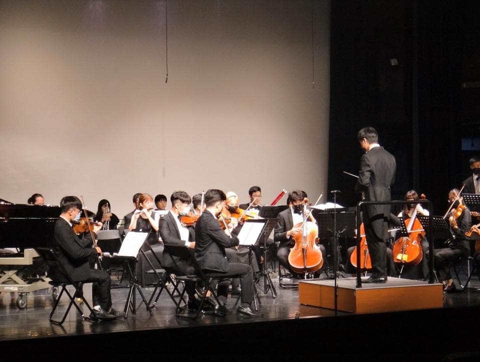 這張照片是一場弦樂演奏會,最重要的是樂團的表演,包括演奏員們的專注神情,他們的樂器,以及他們演奏時的動作。