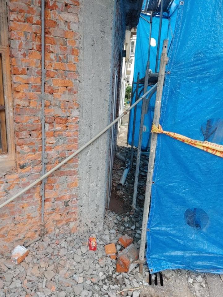 這張照片是一棟建築工地的側面,最主要的部分是一片藍色的防水布,它被用來遮蔽工地,以防止雨水或其他天氣影響建築工程。