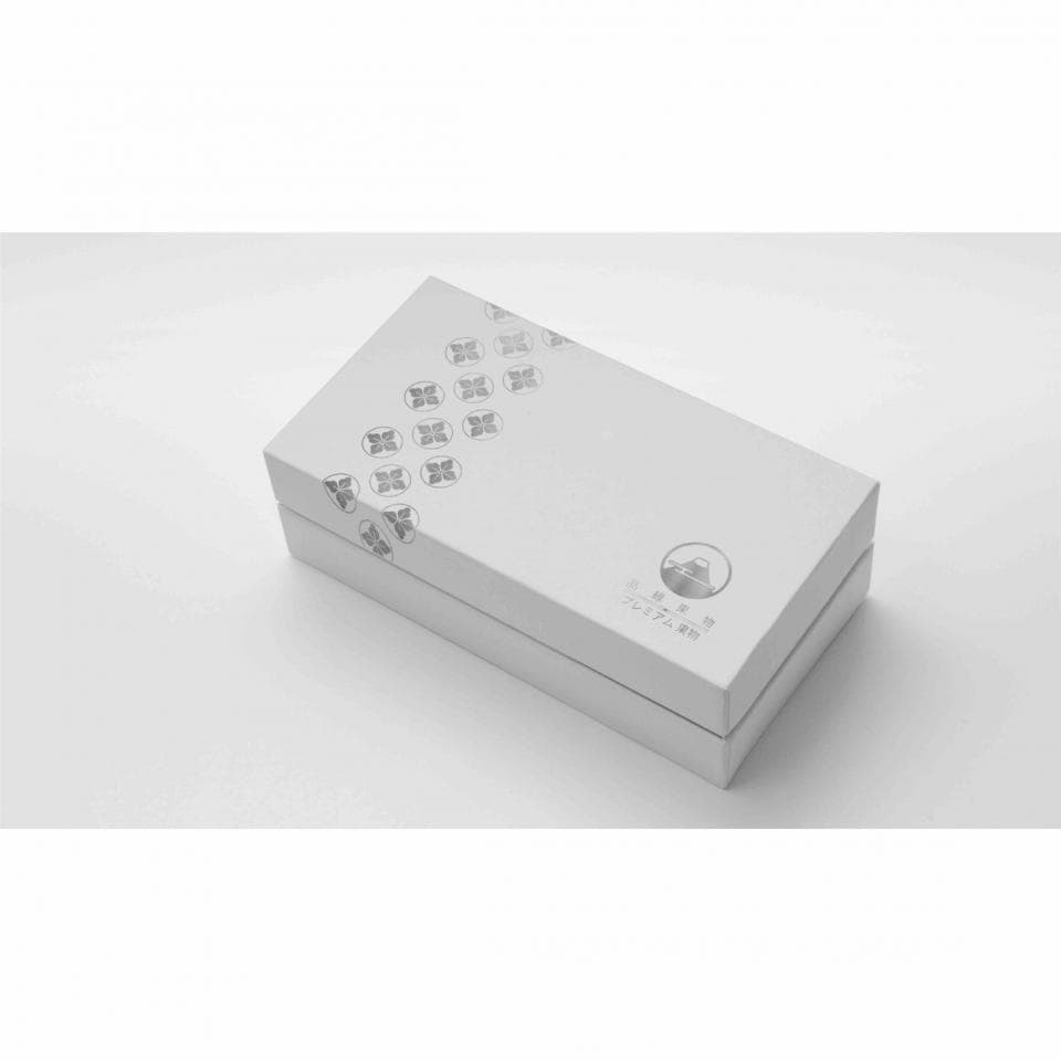 這張照片是一個印有圖案和文字的白色盒子。 盒子上有重複的圖案,以及一個圓形標誌,標誌中包含一個建築物。