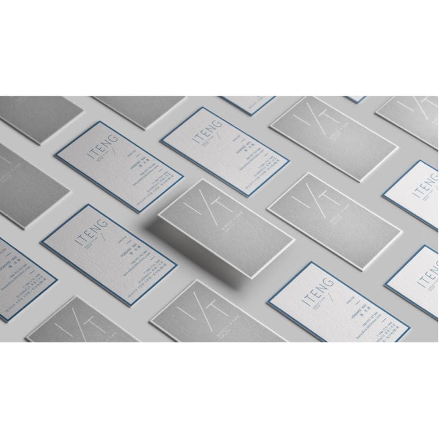 這張照片是一堆疊在一起的灰色名片,上面印有「ITENG」的字樣和設計。名片被排列成一個有規則的模式,給人一種簡潔、專業的感覺。