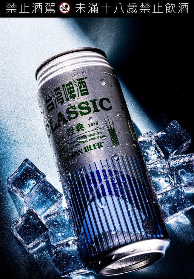 這張「臺灣啤酒」的照片是一罐經典的臺灣啤酒,罐身上有「CLASSIC」字樣,並有綠色的麥穗圖案,周圍有冰塊。