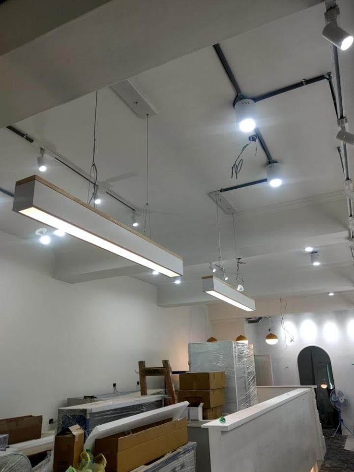 這張照片是正在裝修的店面,重點是天花板上的兩盞長條形燈,它們用簡約的白色木框裝飾,顯得格外明亮舒適。