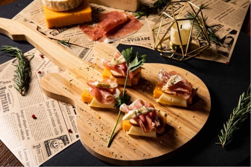 這張「吉他造型的木板」的照片是一個擺放著小點心和水果的餐盤。