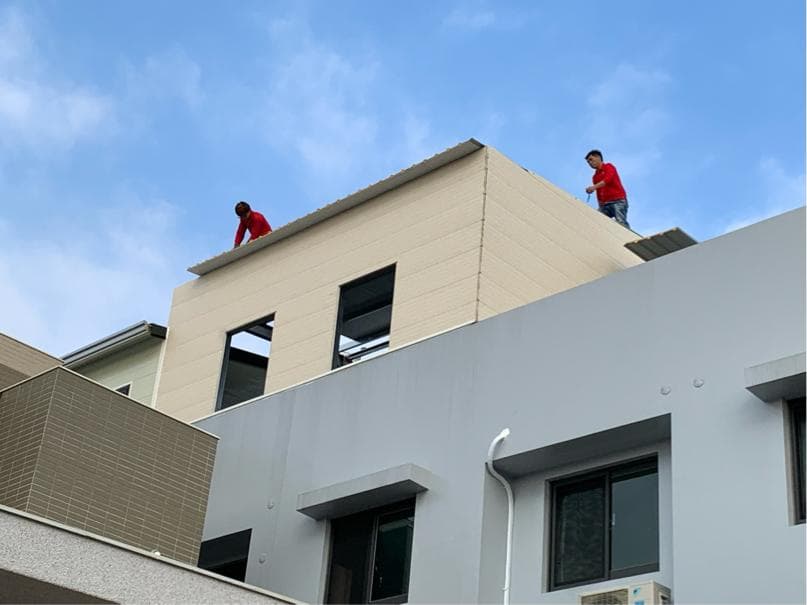 1. 照片顯示一棟正在施工的建築物,上面有兩位工人