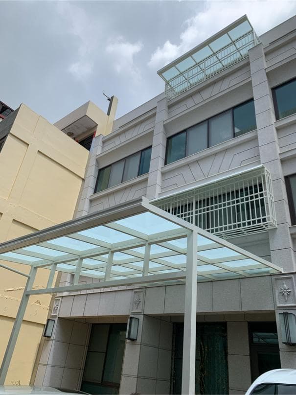 這張「房屋外觀」的照片是 一棟現代風格的建築,建築外觀以白色為主,並配有玻璃屋頂的遮雨棚。