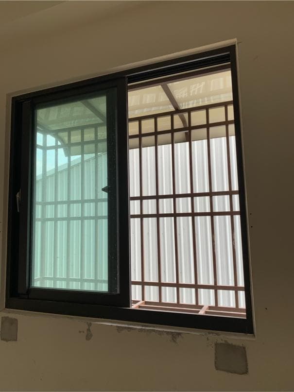 1) 照片顯示一個黑色窗戶,窗戶上裝有鐵製的窗格,窗戶看起來是新的