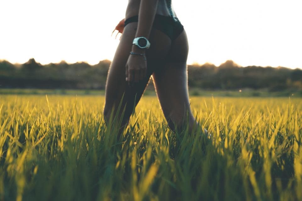 這張「女人在田野中行走」的照片是一個穿著比基尼的女性從畫面左側走向右側,她穿著黑色比基尼,手臂上戴著手錶。