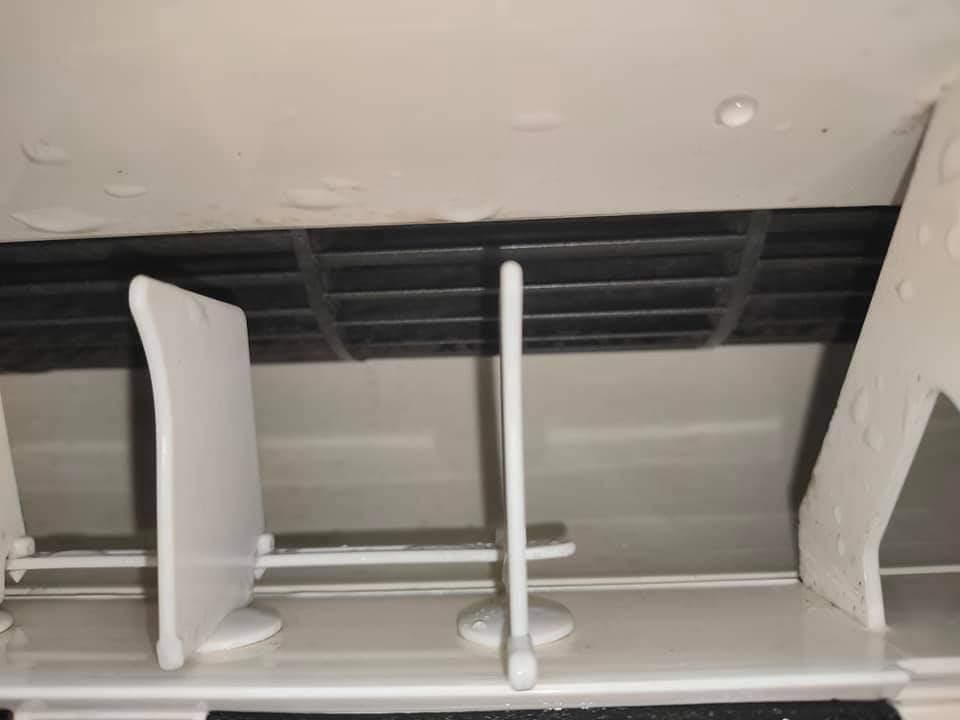 1) 照片顯示一個髒的空調內部,包含灰塵、水滴和可見的髒污