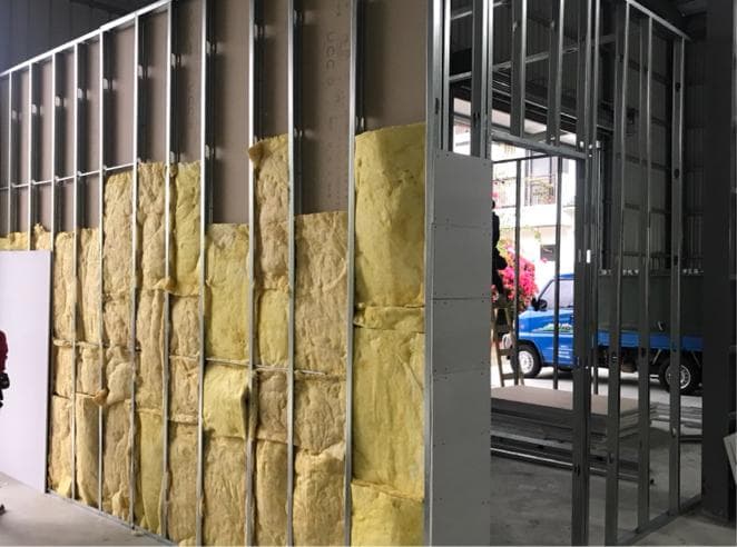 1. 照片顯示一個正在建造中的牆壁,牆壁上裝有隔熱材料