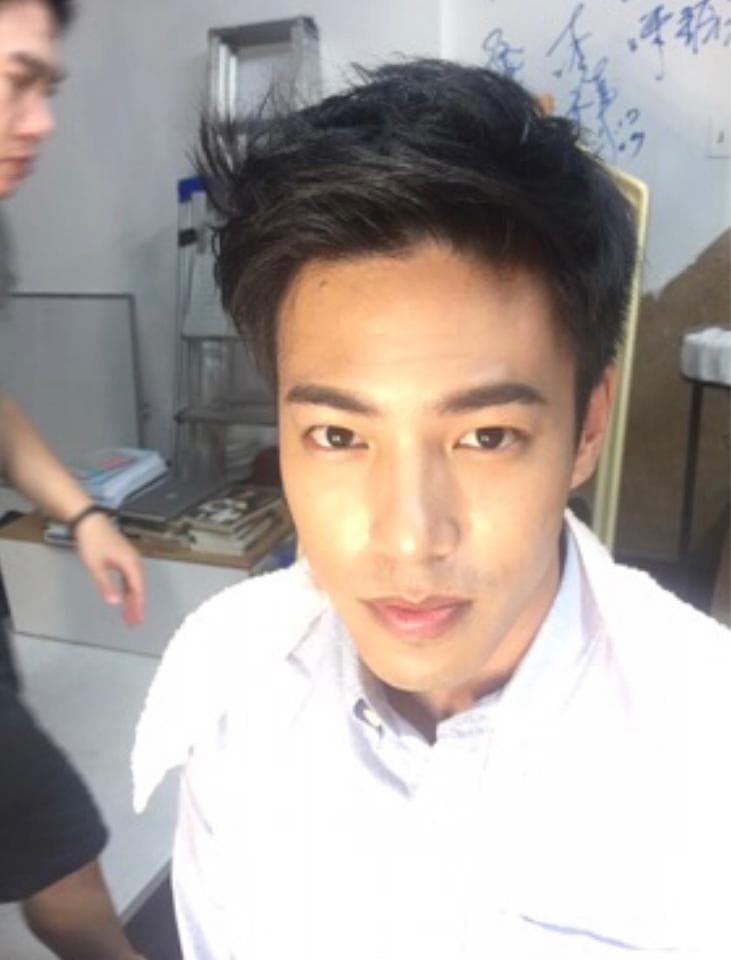 這張照片是一個年輕的男性。他穿著一件白色襯衫,頭髮很短,看起來很乾淨。他的眼睛很大,嘴唇很薄。他正看著鏡頭,顯得很自信。