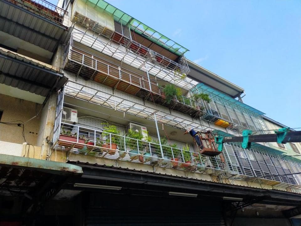 1) 這張照片顯示一座帶有許多陽台的建築物,陽台上有許多盆栽